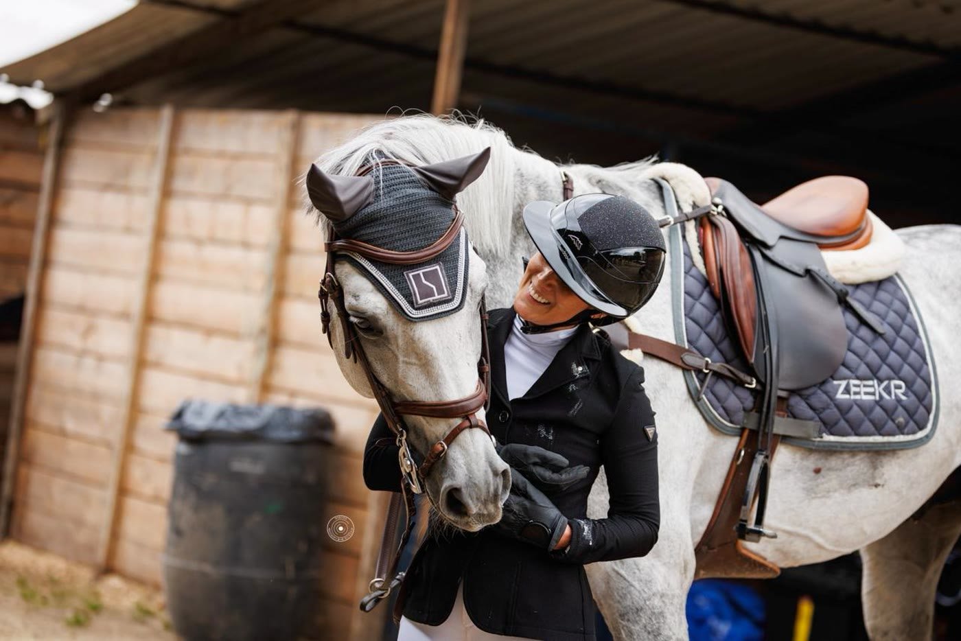 Jinete sonriendo junto a su caballo, retrato